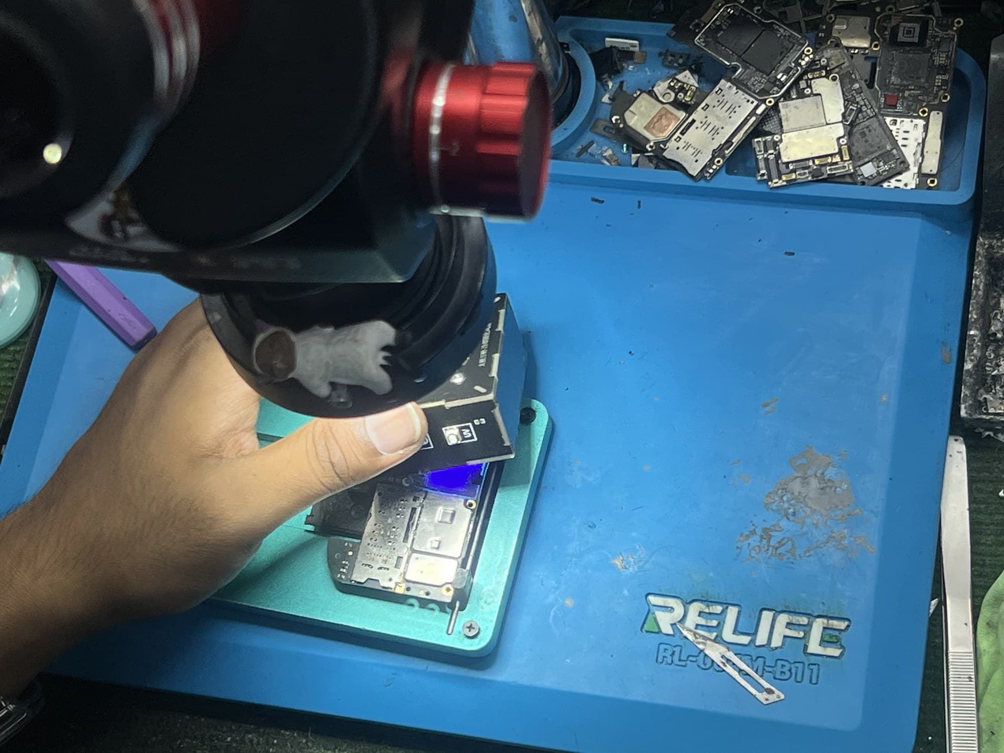 Technician performing UV curing during phone board repair